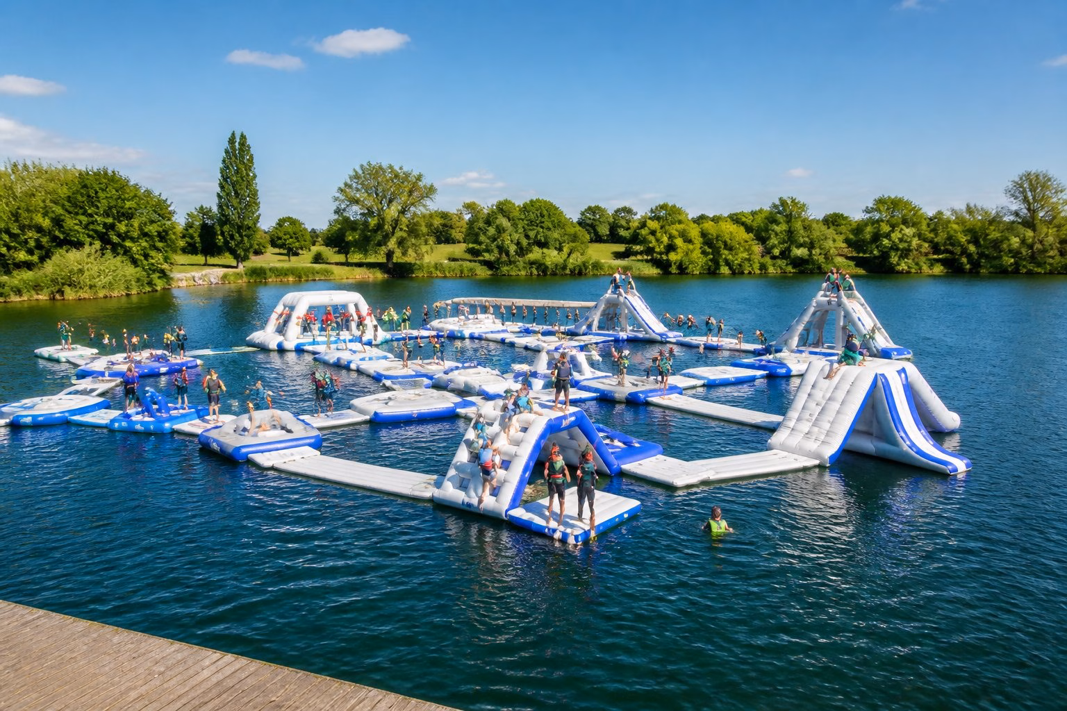 People enjoying an inflatable aqua park on a lake near Windsor.