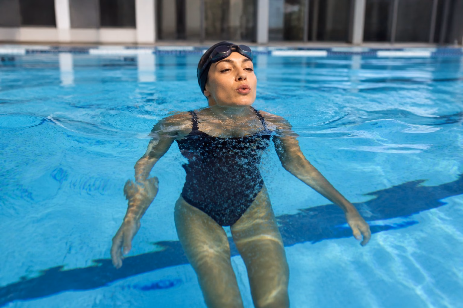 Swimmer practising a bobbing breathing drill in a swimming pool.