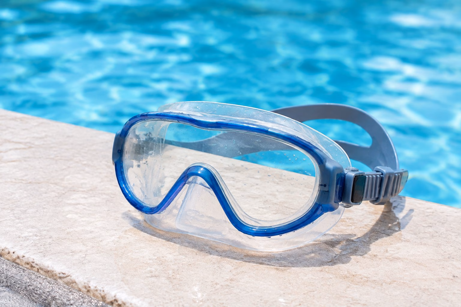 A swimming mask beside a pool.